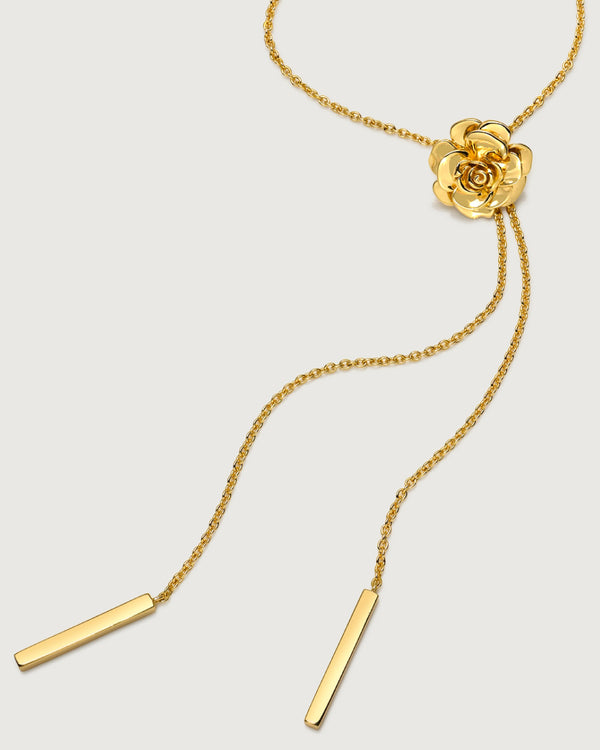 photo of a gold rose-shaped pendant necklace on a bolo chain