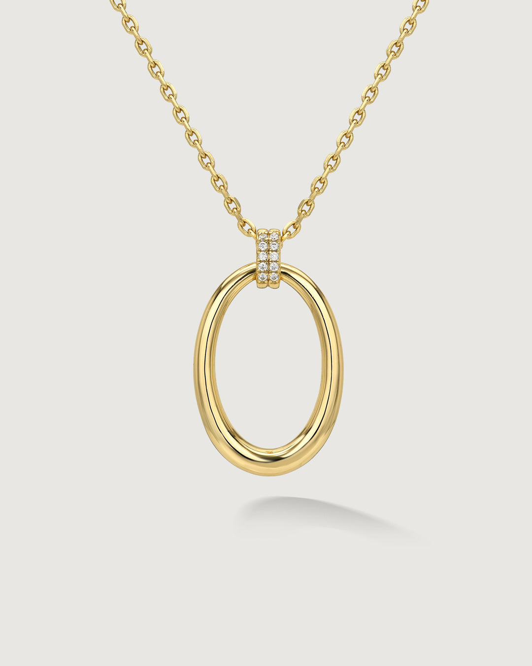 Gold open oval pendant necklace by Camóre on a white background