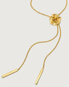 photo of a gold rose-shaped pendant necklace on a bolo chain