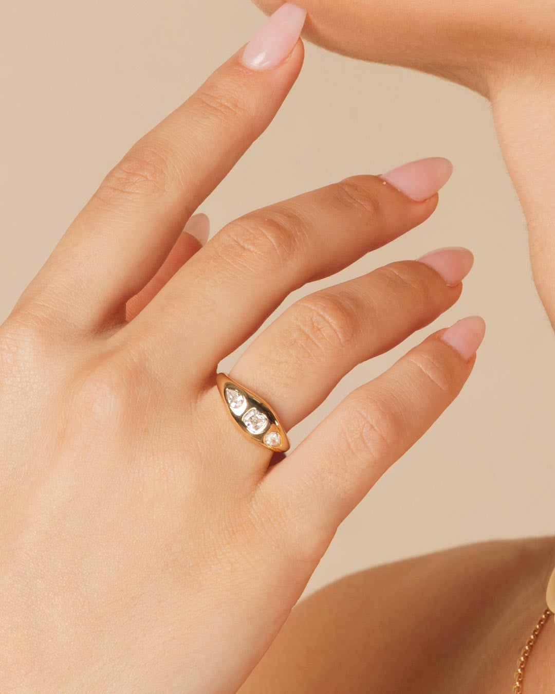 model wearing a gold ring with 3 mixed cut stones in a gypsy setting by Camóre