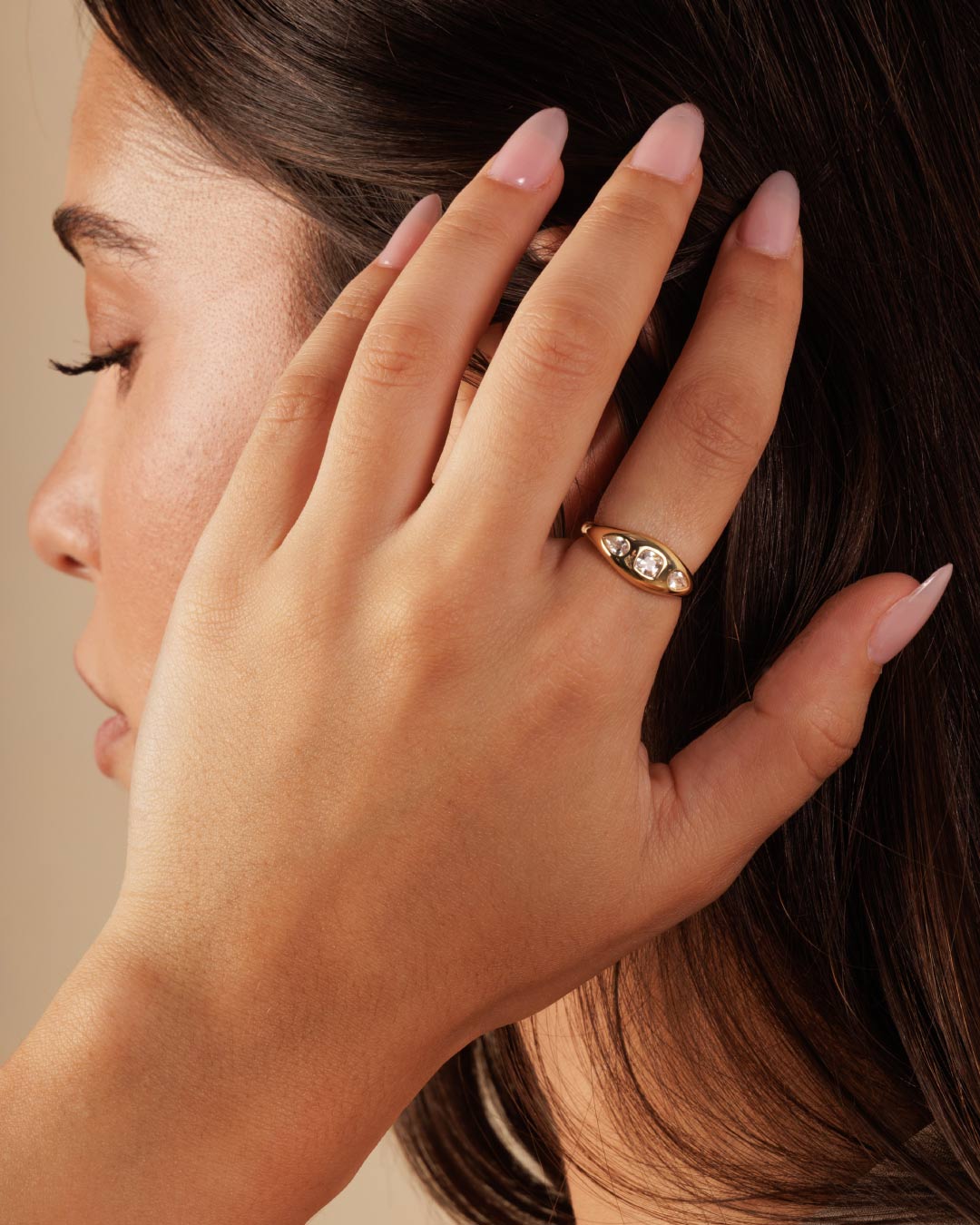 model wearing a gold ring with 3 mixed cut stones in a gypsy setting by Camóre